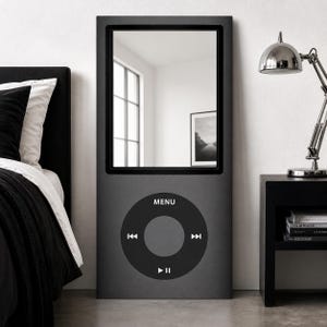 May include: A tall, rectangular floor mirror designed to resemble a classic digital music player. The frame is matte dark gray with a large, reflective glass surface at the top and a circular control interface at the bottom featuring the text MENU.