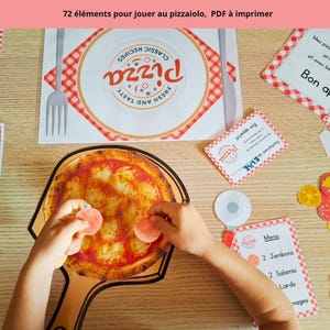 May include: A printable pizza-making play set featuring 72 elements including a paper pizza on a peel, menus, place mats, and various topping cutouts. The set includes text such as "72 éléments pour jouer au pizzaiolo, PDF à imprimer" and "Restaurant de Elise".