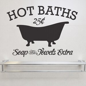 May include: Black and white vinyl decal with the text "HOT BATHS 25¢" and a silhouette of a bathtub. Below the bathtub is the text "Soap & Towels Extra".