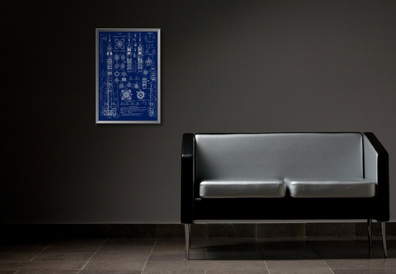 May include: A black and silver two-seater sofa with a blueprint design framed on the wall behind it.
