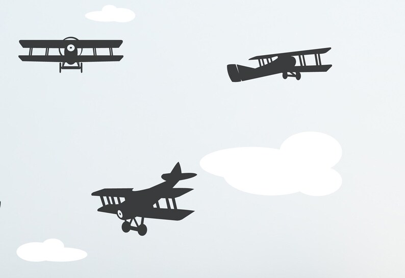 May include: A white background with three black silhouette images of airplanes. The airplanes are flying in different directions. There are also white clouds in the background.