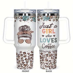 May include: A white stainless steel tumbler with a handle, straw, and clear lid. The design features a leopard print pattern, tropical leaves, and an illustration of a person with a messy bun and leopard print sunglasses. Text reads: Just a G1RL who LOVES Coffee. Add your name.