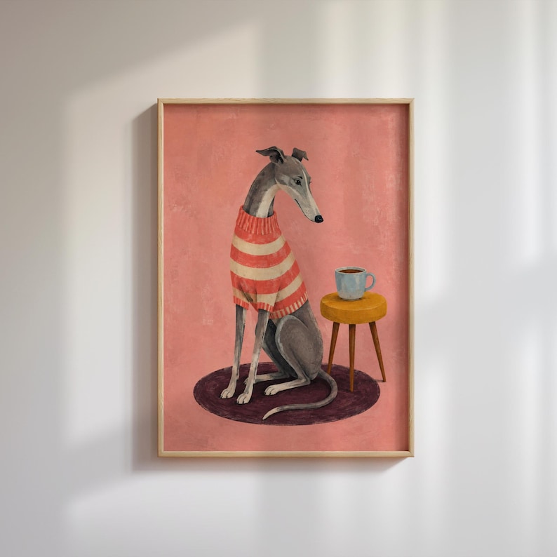 Puede incluir: Una l&aacute;mina de arte mural enmarcada que muestra a un galgo con un su&eacute;ter de rayas rojas y blancas. El perro est&aacute; sentado sobre una alfombra circular de color morado oscuro junto a un peque&ntilde;o taburete amarillo de tres patas con una taza azul claro.