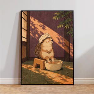 May include: A framed wall art print depicting a hedgehog with a white towel wrapped around its head, sitting on a small wooden stool while soaking its feet in a round stone basin. The scene is set in a room with a shoji screen and maple leaves.