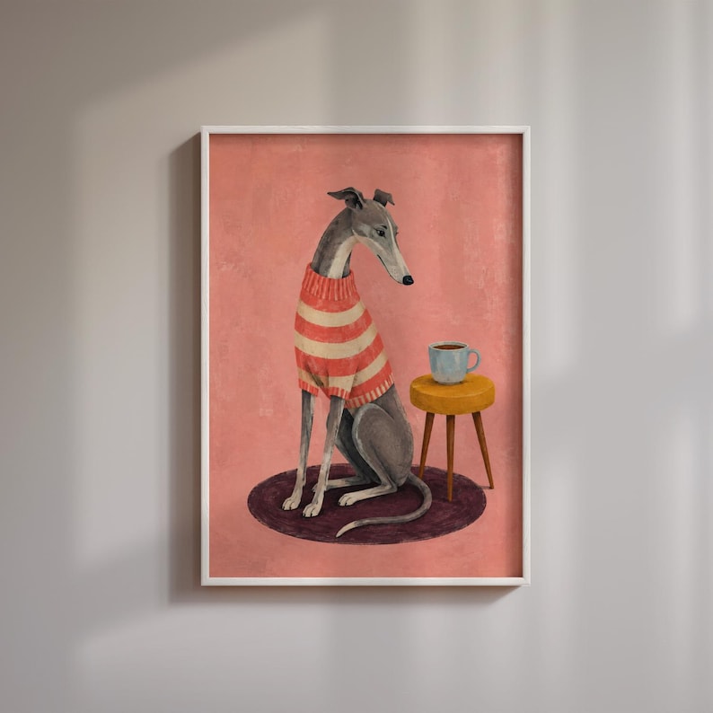 Puede incluir: Una l&aacute;mina enmarcada que muestra a un galgo con un su&eacute;ter de rayas rojas y blancas. El perro est&aacute; sentado sobre una alfombra circular de color morado oscuro junto a un peque&ntilde;o taburete amarillo con una taza azul claro, sobre fondo rosa.