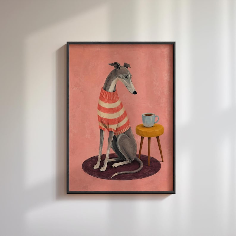 Puede incluir: Una l&aacute;mina de arte enmarcada que muestra a un galgo con un su&eacute;ter de rayas rojas y blancas, sentado sobre una alfombra circular oscura junto a un peque&ntilde;o taburete amarillo con una taza azul claro, sobre un fondo rosa empolvado.