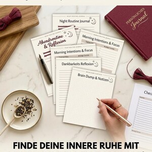Könnte beinhalten: Eine Sammlung druckbarer Journal-Seiten wie Night Routine Journal, Abendroutine & Reflexion, Morning Intentions & Focus, Dankbarkeits Reflexion und Brain Dump & Notizen, ergänzt durch ein bordeauxrotes Notizbuch, einen Stift und eine Schale mit Teeblättern.