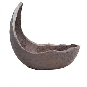 May include: A crescent moon-shaped bowl with a dark brown, textured, and matte finish. The object features a deep, curved interior and a rough, uneven exterior surface, resembling a natural stone or clay construction with a wide, open top.