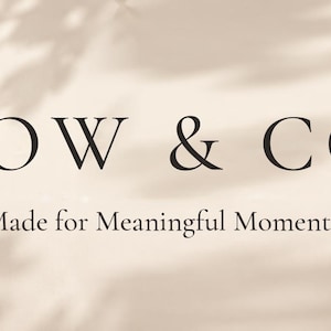 May include: A woven blanket with a duck pattern and fringed edges, partially visible in the corner. The text TOW & CO. and Made for Meaningful Moments. is centered on a light beige background with soft, dappled leaf shadows.