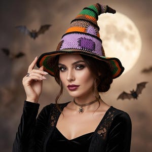Può includere: Un cappello da strega all'uncinetto con un design patchwork in vivaci filati arancioni, viola, verdi e marroni. Il cappello presenta una punta leggermente curva e una tesa ampia e ondulata con un bordo nero, mostrando punti dettagliati.