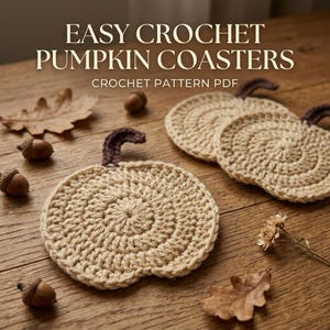 Op de afbeelding: Drie ronde, beige gehaakte onderzetters in de vorm van pompoenen, elk met een donkerbruine steel. De tekst "EASY CROCHET PUMPKIN COASTERS" en "CROCHET PATTERN PDF" staat erboven, samen met verspreide eikels en eikenbladeren als decoratie.