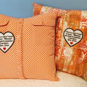 May include: Two orange and white patterned pillow covers with a heart-shaped patch sewn on each. The patch has black text that reads "This is a shirt I used to wear. Whenever you hold it remember I am there. Love, Gram".