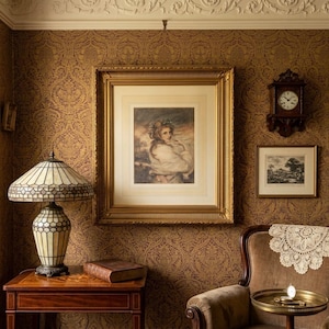 May include: A stained glass lamp with a geometric pattern sits on a wooden table next to a book. A large gold-framed portrait of a person hangs on a patterned wallpaper wall, accompanied by a wooden wall clock and a smaller framed landscape print.