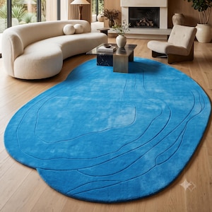 Handgetuft effen helderblauw wollen vloerkleed met abstracte, onregelmatige vorm, moderne organische, golvende contouren en uitgesneden lijnen, luxueuze textuur en decoratie.