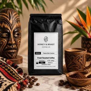Könnte beinhalten: Eine schwarze Kaffeetüte mit weißem Etikett, auf dem Honey & Roast Coffee Co, Herkunft Papua-Neuguinea und ein Nettogewicht von 340g stehen. Das Etikett zeigt ein Tassensymbol, den Mahlgrad Standard sowie Informationen zu den Kaffeebohnen.