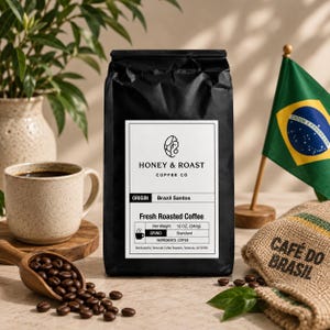 May include: A black bag of Honey & Roast Coffee Co. Brazil Santos coffee with a white label stating 12 OZ. (340g) net weight, standard grind, and coffee ingredients. The bag is accompanied by a ceramic mug, a wooden scoop of beans, and a Brazilian flag.