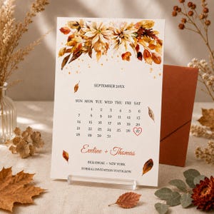 May include: A rectangular wedding save the date card featuring a watercolor illustration of autumn leaves and flowers at the top. The text reads SEPTEMBER 20XX, the calendar dates, the names Eveline + Thomas, and BELLEROSE NEW YORK.