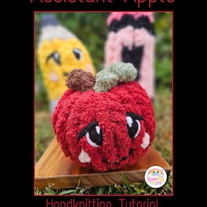 May include: A red crocheted apple plush with a brown stem and green leaf, featuring black and white embroidered eyes and a small smile. The text Assistant Apple Handknitting Tutorial PDF & Video is displayed in red against a black border.