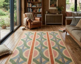May include: A rectangular area rug featuring a geometric pattern of interlocking circles and vertical stripes in muted shades of pink, sage green, blue, and terracotta orange, finished with a short fringe along the two shorter edges.