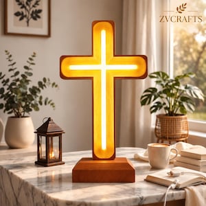 Può includere: Una lampada a forma di croce in legno con una striscia luminosa calda integrata al centro. La croce è montata su una solida base rettangolare in legno. Il design presenta linee pulite e una finitura liscia, offrendo un'illuminazione soffusa.