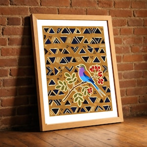 May include: A framed print featuring a colorful bird with a purple head, blue chest, and brown wings perched on a branch with red flowers. The background is a mustard yellow field decorated with a repeating pattern of dark blue triangles and lines.