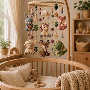 Könnte beinhalten: Ein rundes Häkel-Mobile für Babys mit hängenden Stofffiguren eines grauen Hasen, eines cremefarbenen Einhorns, eines rosa Fuchses, eines weißen Schafs, eines braunen Rehs und eines grünen Drachen, ergänzt durch kleine gehäkelte Kugeln, Sterne, Blätter und eine Wolke.