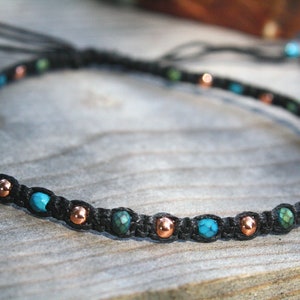 May include: A black cord bracelet with turquoise and copper beads.