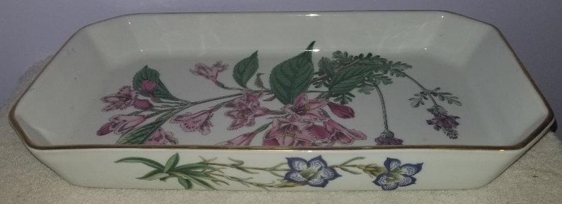 May include: White ceramic baking dish with a gold rim and a floral design featuring pink and green flowers.