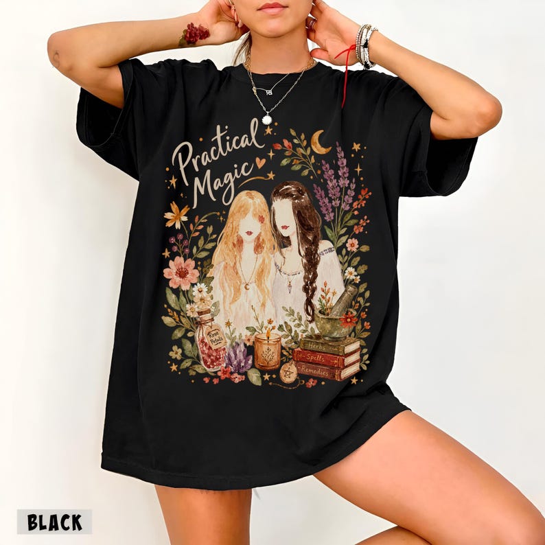 May include: A black t-shirt featuring a graphic print of two figures with long hair surrounded by flowers, a crescent moon, a jar labeled Rose Petals, a candle, a mortar and pestle, and a stack of books labeled Herbs, Spells, and Remedies.