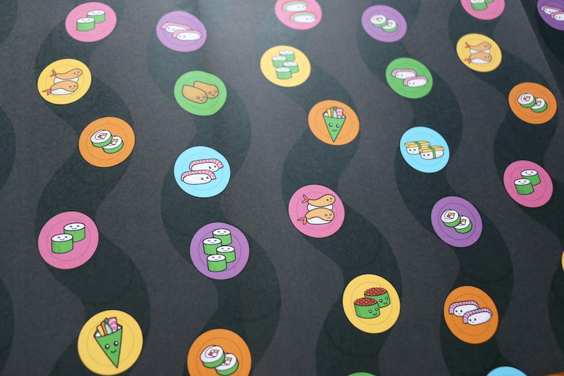 May include: A black background with colourful circles featuring different types of sushi. The sushi is illustrated with cartoon faces.