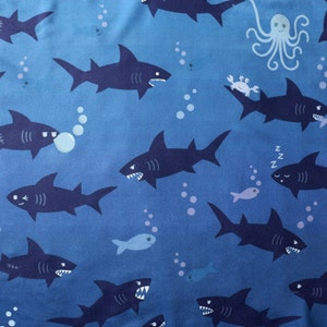 Shark pattern in blue, with fun, quirky details of sharks getting up to mischief.