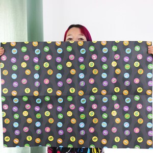 May include: Black and white wrapping paper with a repeating pattern of colourful circles. Each circle features a different design, including a variety of food items.