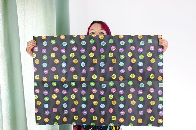 May include: Black and white wrapping paper with a repeating pattern of colourful circles. Each circle features a different design, including a variety of food items.