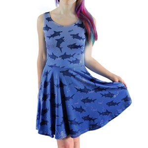 Sleeveless skater dress (just above knee length) in blue with a pattern of sharks. The skirt is a full circle skirt - swishy and fun to wear!