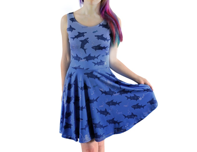 Sleeveless skater dress (just above knee length) in blue with a pattern of sharks. The skirt is a full circle skirt - swishy and fun to wear!