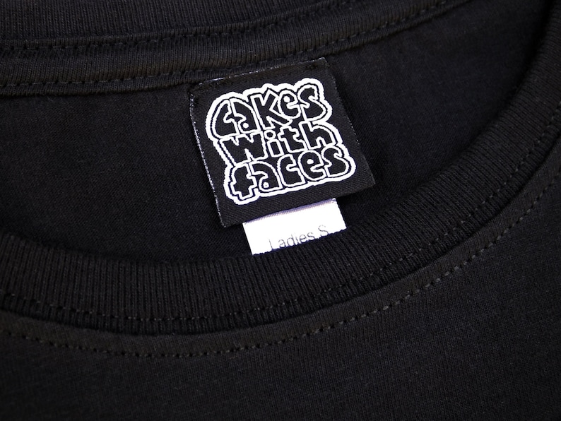 May include: Black t-shirt with a white tag that says "Cakes With Faces" and "Ladies S".