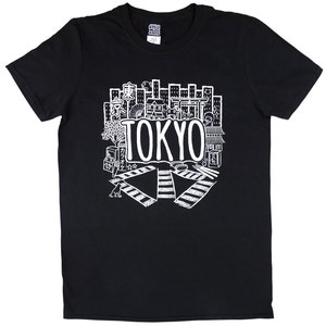 May include: Black t-shirt with a white graphic design of a cityscape with the word "TOKYO" in large letters. The design includes various Japanese symbols and icons.