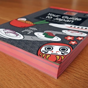 Japan travel guide book with red page edges.