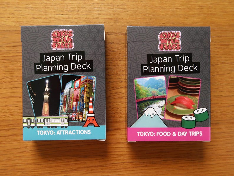 Op de afbeelding: Twee grijze kaartspellen met kleurrijke afbeeldingen en tekst. De bovenste kaart van elk spel heeft de tekst "Japan Trip Planning Deck". De linker kaart heeft een afbeelding van de Tokyo Tower en de tekst "TOKYO: ATTRACTIONS". De rechter kaart heeft een afbeelding van de Mount Fuji en de tekst "TOKYO: FOOD & DAY TRIPS".