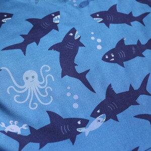 Close-up of the shark pattern: two sharks are fighting over a fish, and there's a cheeky octopus.