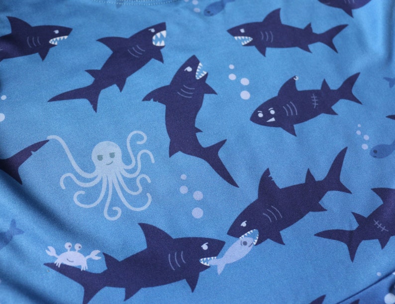 Close-up of the shark pattern: two sharks are fighting over a fish, and there's a cheeky octopus.