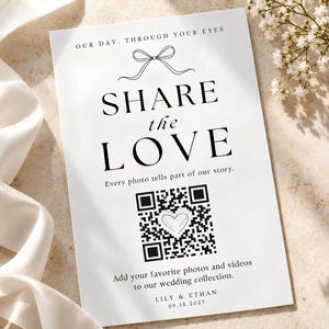 May include: A white rectangular wedding sign with black text reading OUR DAY, THROUGH YOUR EYES, SHARE the LOVE, Every photo tells part of our story, Add your favorite photos and videos to our wedding collection, LILY & ETHAN, 09.18.2027, and a QR code.