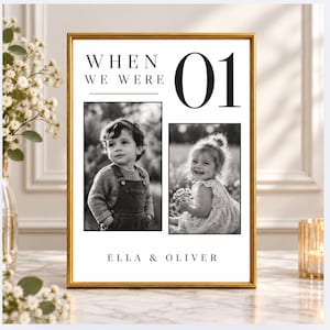 May include: A rectangular gold-toned frame containing a white print with the text "WHEN WE WERE 01" and "ELLA & OLIVER". The print features two black and white photographs of young children, one wearing overalls and one in a floral dress.