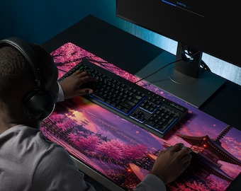 May include: A large rectangular desk mat featuring a vibrant digital illustration of a traditional pagoda surrounded by blooming pink cherry blossom trees at sunset. The mat sits under a black computer keyboard and mouse on a dark desk surface.