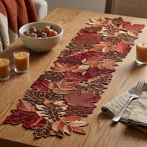 May include: A table runner featuring an intricate arrangement of embroidered autumn leaves in shades of deep red, burnt orange, and dark brown. The runner is composed of individual leaf-shaped segments stitched together to create a long, decorative piece.