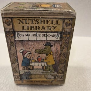 May include: A rectangular box titled Nutshell Library by Maurice Sendak. The front features a brown-toned illustration of a child in a blue coat and a green alligator in a yellow jacket sitting at a table, with a black cat and a mouse below.