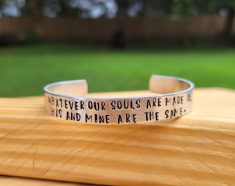 May include: Silver bracelet with the inscription "Whatever our souls are made of, his and mine are the same."