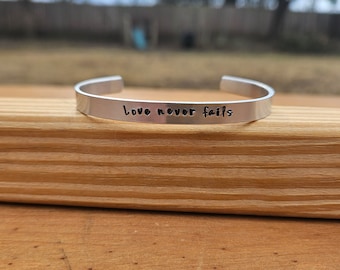 Love Never Fails - 1 Corinthians 13:4-8 metal stamped Bible verse cuff bracelet - 2/8 inches wide - aluminum