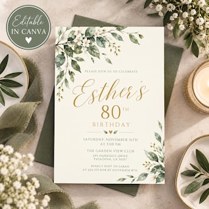 May include: A rectangular birthday invitation card featuring a cream background with green watercolor leaves and white flowers. The text reads: Please join us to celebrate Esther's 80th birthday, Saturday, November 16th at 3:00 PM, The Garden View Club.