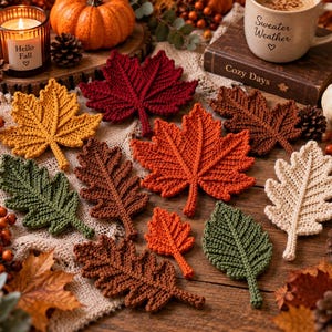 Op de afbeelding: Een verzameling gehaakte bladonderzetters in diverse herfstkleuren, waaronder mosterdgeel, dieprood, oranje, bosgroen, bruin en crème. De bladeren zijn voorzien van gedetailleerde stiksels die de nerven van de bladeren nabootsen.